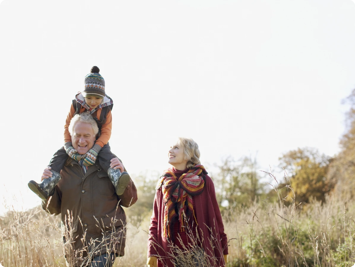 Grandparents walking with grandchild in field